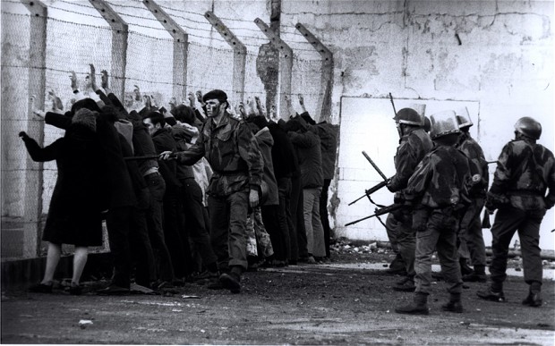 Demonstrators are rounded up by soldiers and lined up against a wall