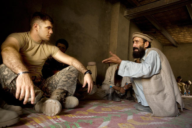 Captain Dan Kearney listens to a villager who came to the army base to demand the release of a detainee named Naim.